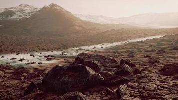 Sunrise in a rocky desert with shadows cast by the hills video