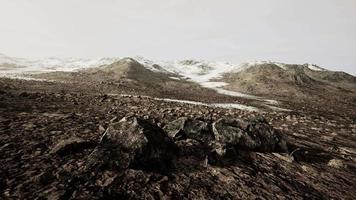 colline rocheuse couverte de neige au milieu du désert par temps nuageux video