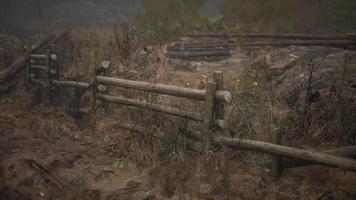 un vecchio recinto di legno con un campo di campagna dietro di esso video