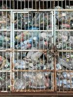 Georgetown, Penang, Malaysia, 2022 - A recycling storage compartment with used bottles and cans. Waiting for pickup photo