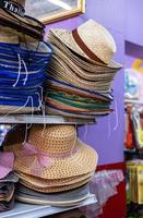 A close-up view of beautiful brown woven hats stacked on top of a retail shelf. photo
