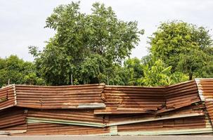 antigua valla galvanizada que rodea el jardín, bosque, árboles en el campo. foto