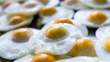 Oil-free fried eggs are lined up on an aluminum tray. photo