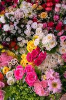 Many colorful artificial fake flowers background blooming beautiful. photo