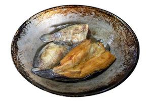 An isolate of an old pan in which salted fish is fried in oil. photo