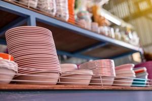Plenty of pink plastic bowls stacked on top of the store shelves. photo