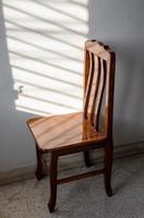 Wooden chairs and sunlight through the shuttered windows onto the walls of the room. photo