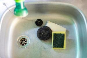 Steel wool and sponge used for cleaning are placed in the sink. photo