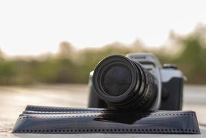 A close-up view of an old black camera and a sheet of film. photo