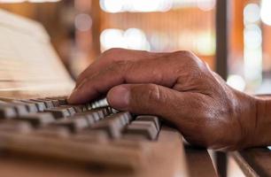 Close-up view of one hand resting on the keyboard. photo