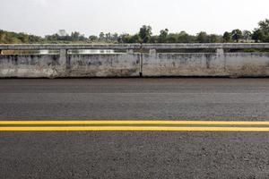 fondo de primer plano de una nueva superficie de carretera asfaltada con rayas amarillas. foto