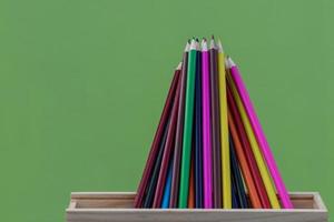 lápices de colores con paredes de hormigón verde. foto