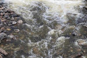 Water flows in streams with many granite rocks. photo