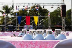 Glasses and cups are placed on the table in front of the stage. photo