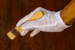 White gloved hand holding a paintbrush. photo