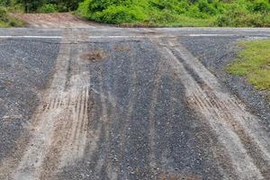 Wet gravel road with car wheel trace. photo