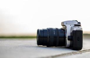 A close-up view of an old black film camera that has been in use for a long time lying. photo