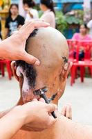 las manos de los monjes están afeitando las cabezas. foto