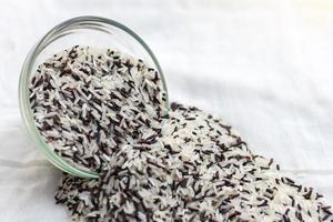 White rice with black overflow cup and upside down on the cloth. photo