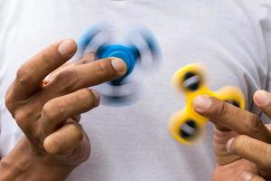 Blue and yellow spinners both in hands. photo