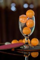 Close-up shot of orange ping pong in clear glass. photo