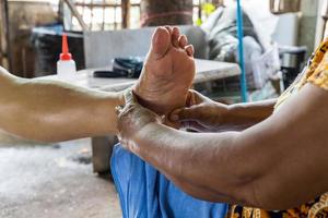 Hand masseuse old woman foot massage. photo