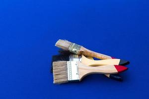 Four painted brushes placed on blue cloth. photo