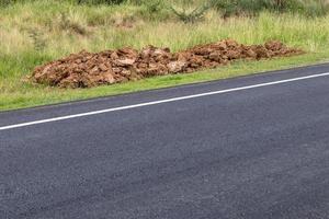 Asphalt road surface with a pile of dirt. photo