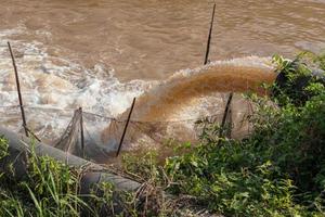 el agua fluye desde la alcantarilla hacia el canal. foto