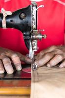 mano mayor con una máquina de coser. foto