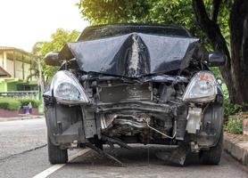 Front of car demolished from collision with electric pole. photo