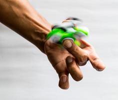 Hands spinner green spin on finger. photo