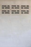 Cement wall with brick ventilation vents. photo