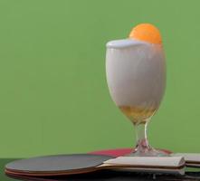 burbujas de cerveza en un vaso con una pelota de ping pong. foto