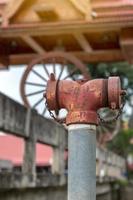 Red fire extinguisher valve pipe head with blurred bridge. photo