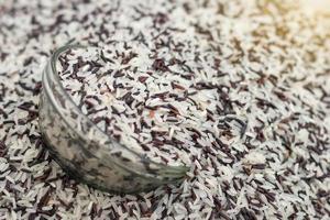 Stack of black and white rice with glass cup. photo