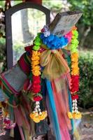 Garlands of fake flowers with colored cloth on a wooden boat head. photo