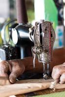 mano masculina con máquina de coser antigua. foto