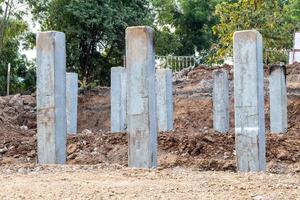 Many concrete poles in the excavated soil. photo