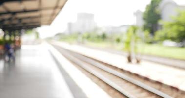 retrato de un joven viajero asiático feliz hablando por teléfono móvil mientras espera el tren en la estación de tren. hombre con máscaras protectoras, durante la emergencia covid-19. video