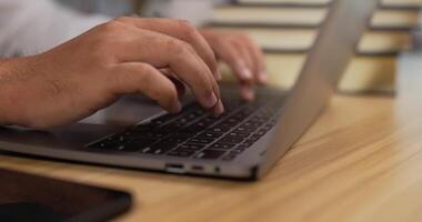 cierre la vista lateral del hombre de la mano usando el dedo con el teclado para escribir en la computadora portátil. manos masculinas trabajando en el teclado del portátil. hombre de negocios usando una computadora portátil. tecnología y concepto de trabajo. video