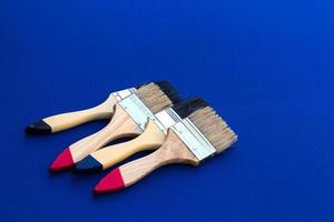 Four painted brushes placed on blue cloth. photo