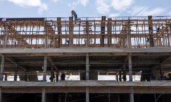 A view from below to the construction of a rowhouse building anchored. photo