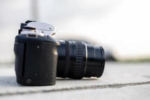 A close-up view of an old black film camera that has been in use for a long time lying. photo