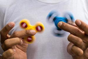 Blue and yellow spinners both in hands. photo