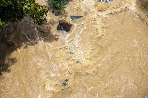 Top view Wild water flows violently through the rocks and shrubs. photo