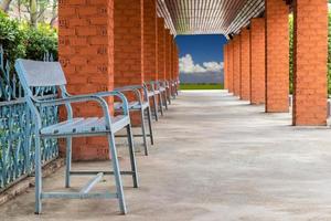 Square brick wall with many benches. photo