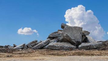 A low angle view, the rubble of large concrete blocks is piled up on the mounds. photo