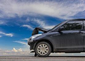 Black front car demolished with sky clouds. photo