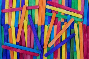 Popsicle sticks of various colors are stacked on top of each other. photo